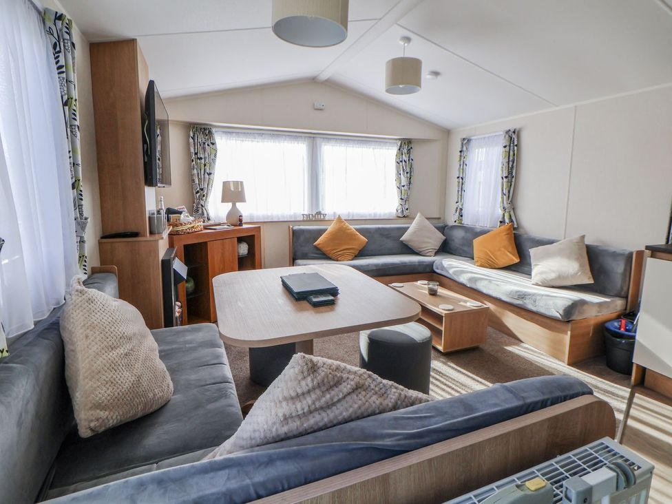 A living room with sofa and coffee table at Chappie's Caravan in Rhyl
