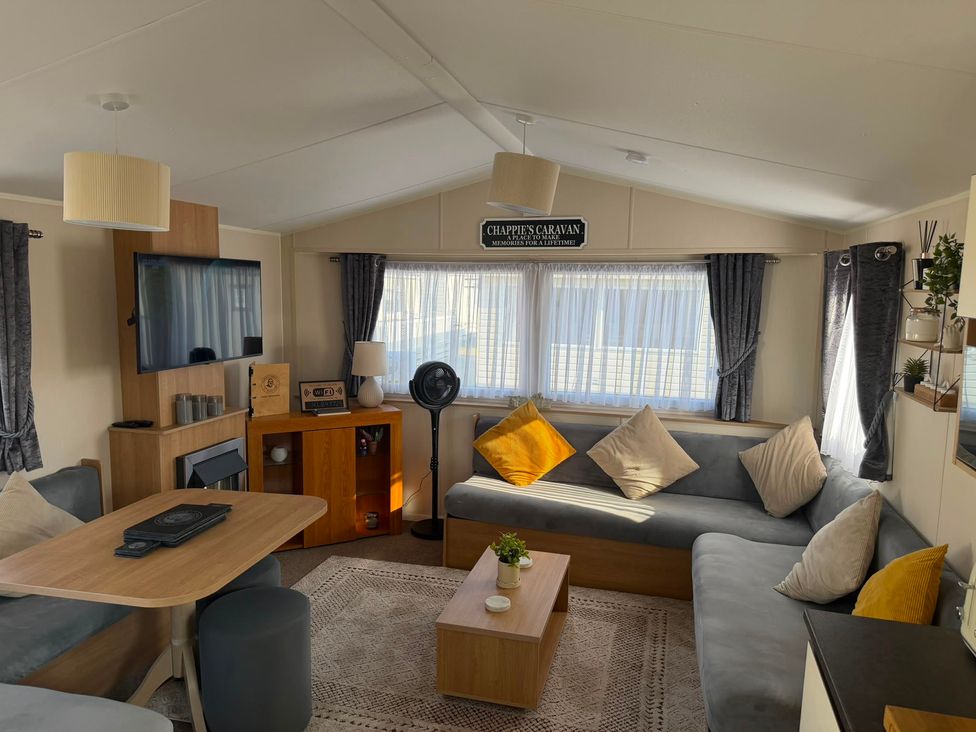 A living room with a sofa and table at Chappie's Caravan 1.0 in Rhyl