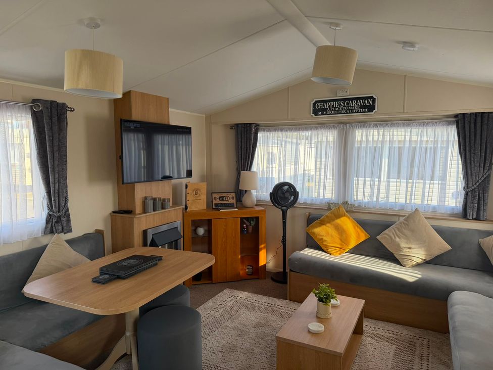 A living room with a couch and television at Chappie's Caravan 1.0 in Rhyl