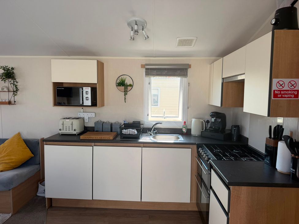 A kitchen with appliances and counter space at Chappie's Caravan 1.0 in Rhyl