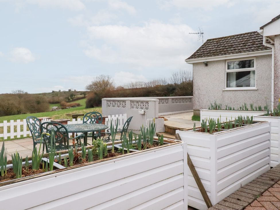 A garden with a table and chairs on a patio at The Bungalow in St. Austell