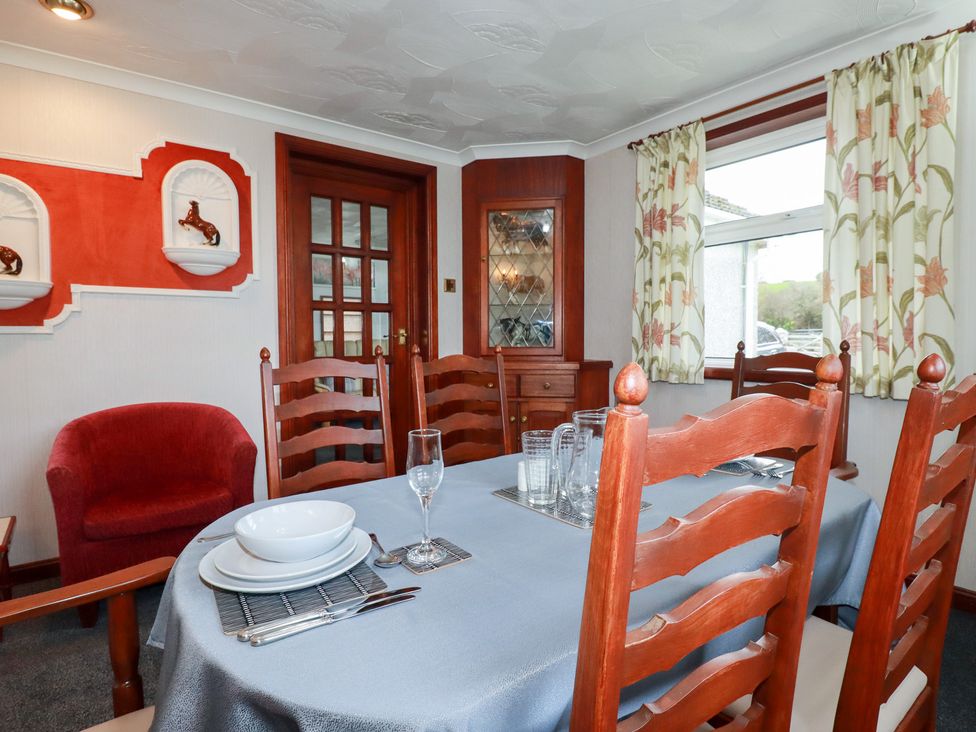 A dining room with a table set for meals at The Bungalow in St. Austell
