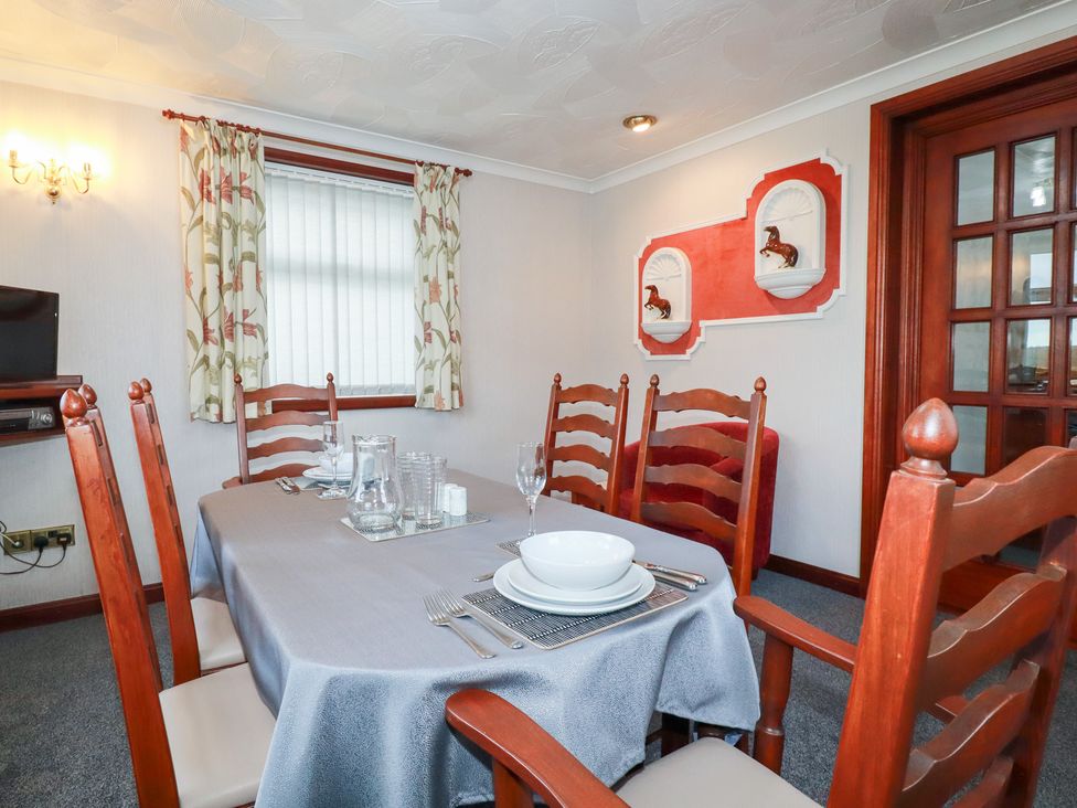 A dining room with a table and chairs at The Bungalow in St. Austell