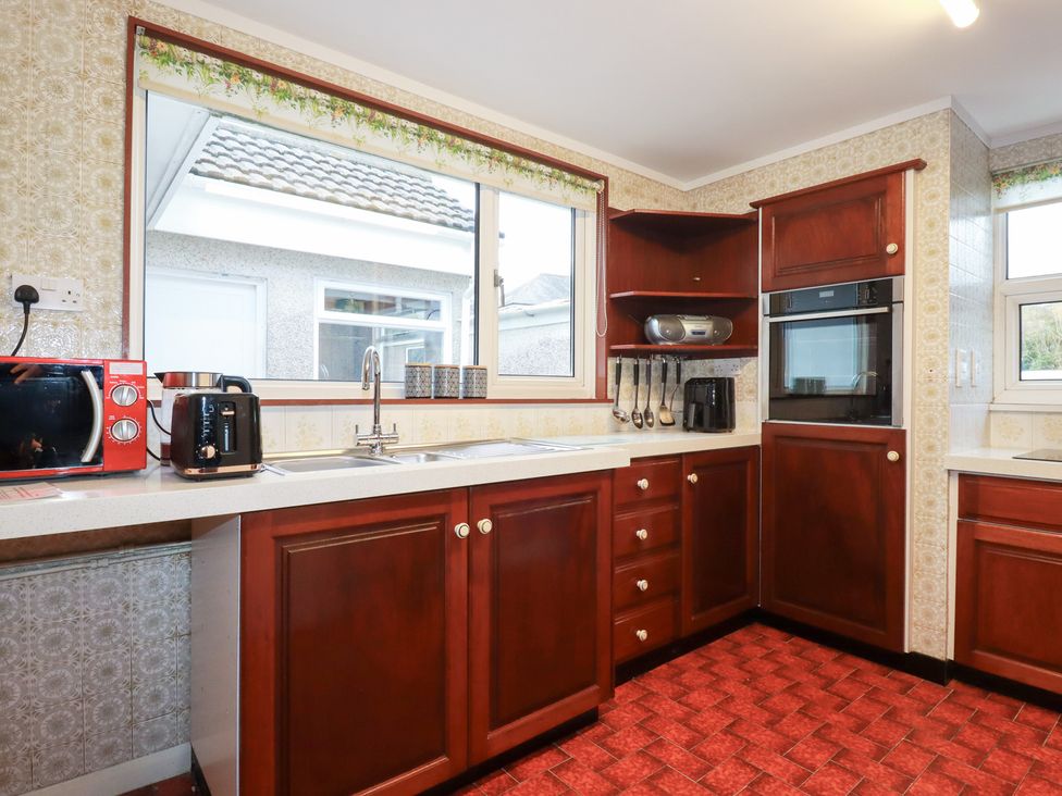 A kitchen with cabinets and appliances at The Bungalow in St. Austell