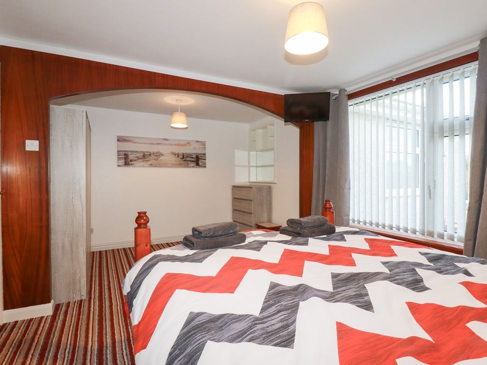 A bedroom with a bed and television at The Bungalow in St. Austell