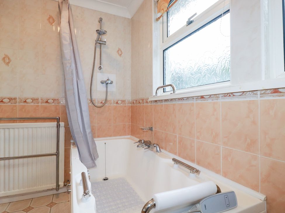 A bathroom with a bathtub and showerhead at The Bungalow in St. Austell