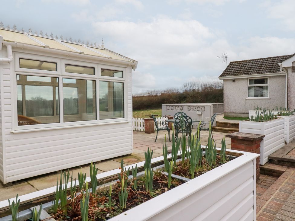 A conservatory with a patio and outdoor seating at The Bungalow in St. Austell