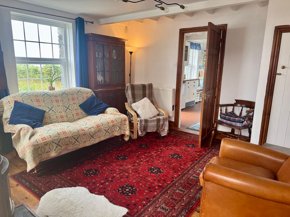 A living room with a sofa and an armchair at Penpegws near Aberystwyth