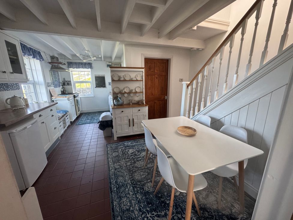A kitchen with a dining area and shelves at Penpegws near Aberystwyth