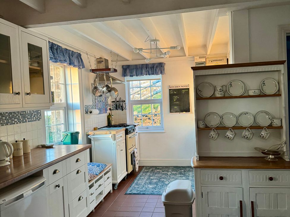 A kitchen with stove, sink, and dish rack at Penpegws near Aberystwyth