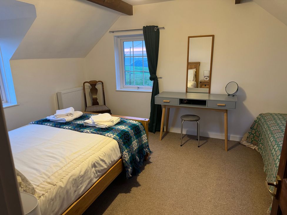 A bedroom with a bed, desk, and window at Penpegws near Aberystwyth