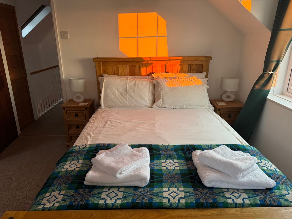 A bedroom with a bed and bedside tables at Penpegws near Aberystwyth