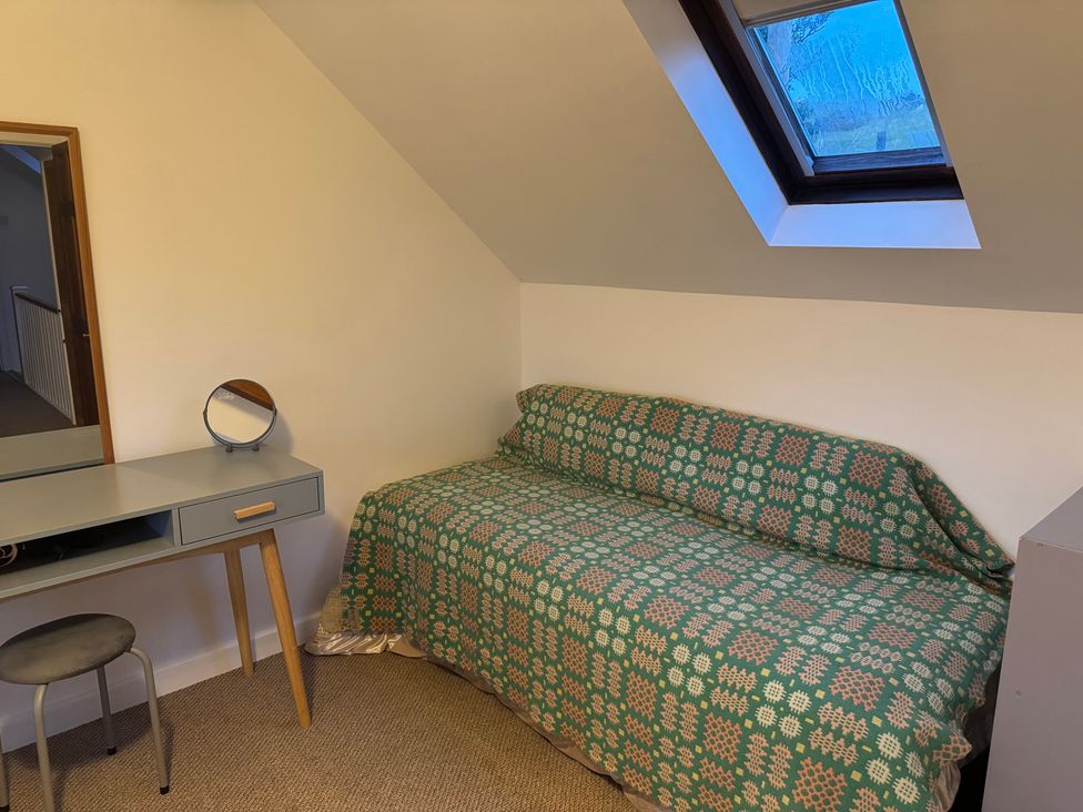 A bedroom with a bed and desk at Penpegws near Aberystwyth
