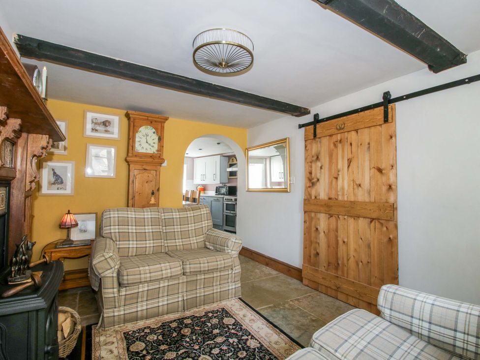 A living room with furniture and a sliding door at Katie's Cottage in Church Stretton