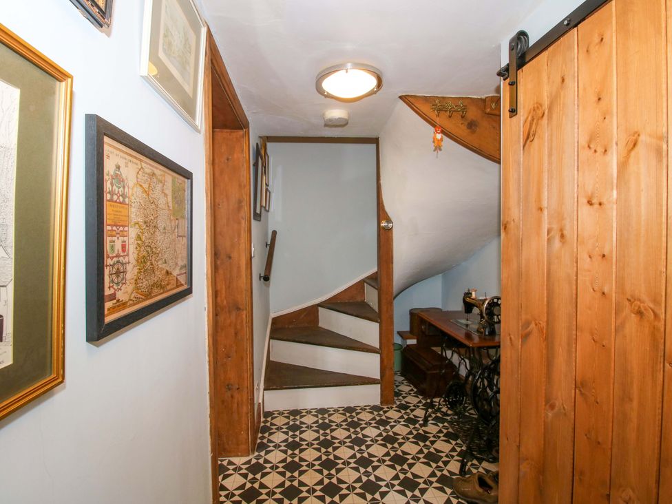 A hallway with a staircase and a sewing machine at Katie's Cottage in Church Stretton