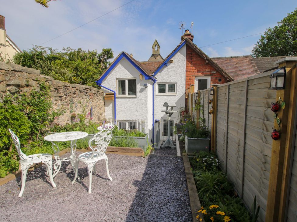 A garden with a table and chairs at Katie's Cottage in Church Stretton