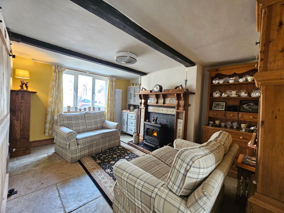 A living room with sofas and a fireplace at Katie's Cottage in Church Stretton