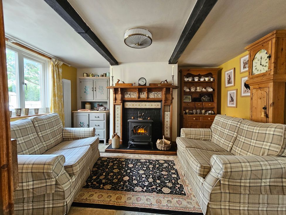 A living room with a fireplace and two sofas at Katie's Cottage in Church Stretton