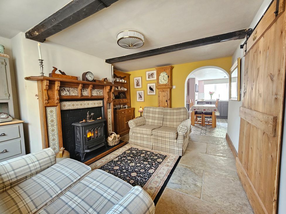 A living room with a fireplace and sofa at Katie's Cottage in Church Stretton