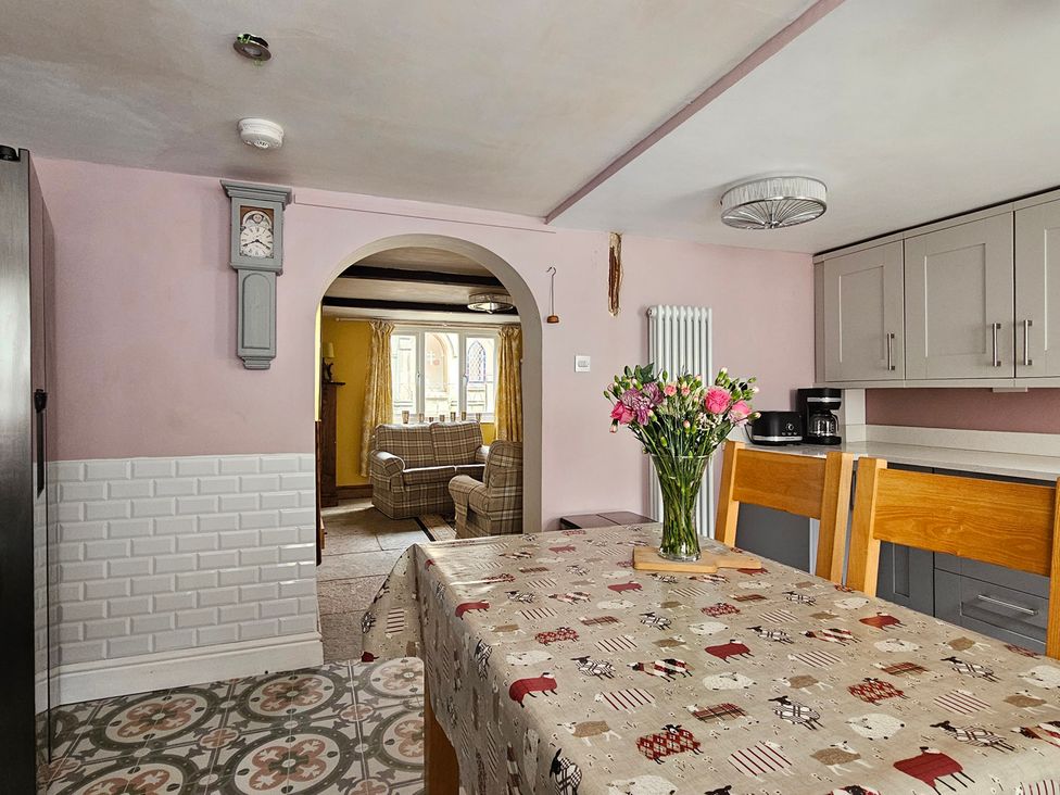 A kitchen with a table and flowers at Katie's Cottage in Church Stretton