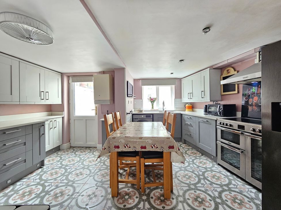 A kitchen with a table and chairs at Katie's Cottage in Church Stretton