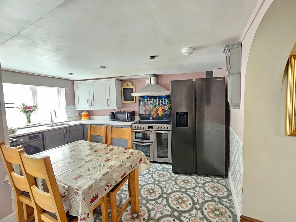 A kitchen with a dining table and appliances at Katie's Cottage in Church Stretton