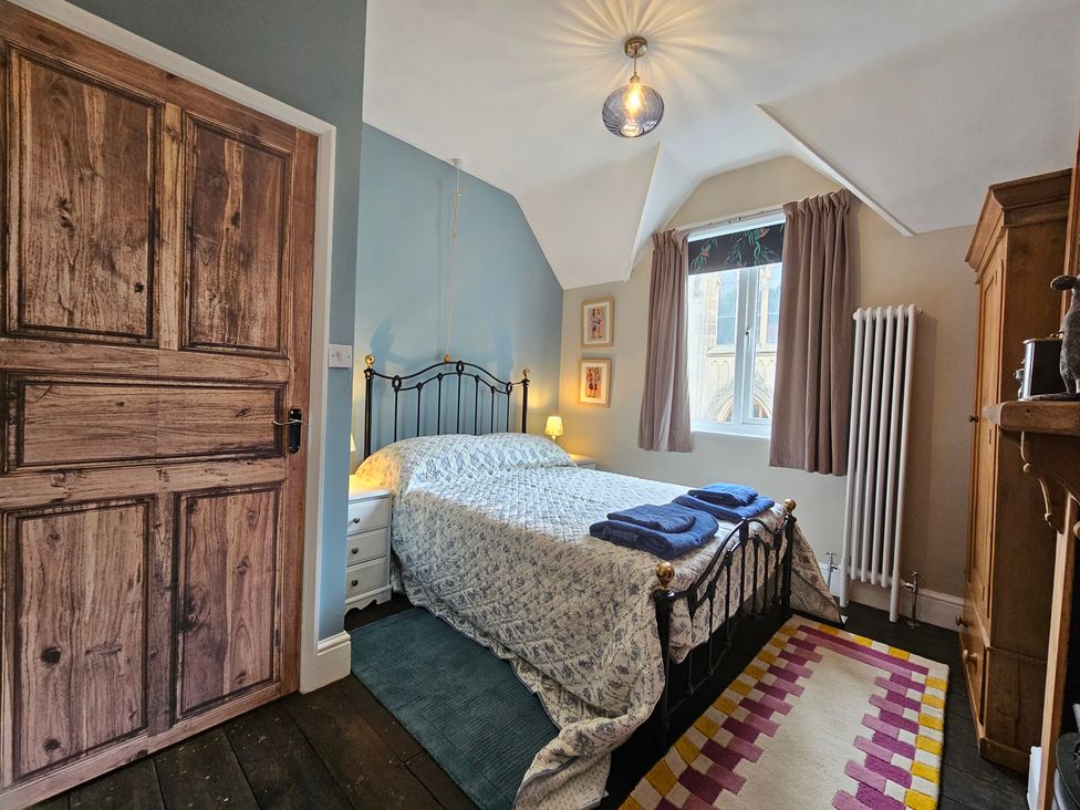A bedroom with a bed and wardrobe at Katie's Cottage in Church Stretton