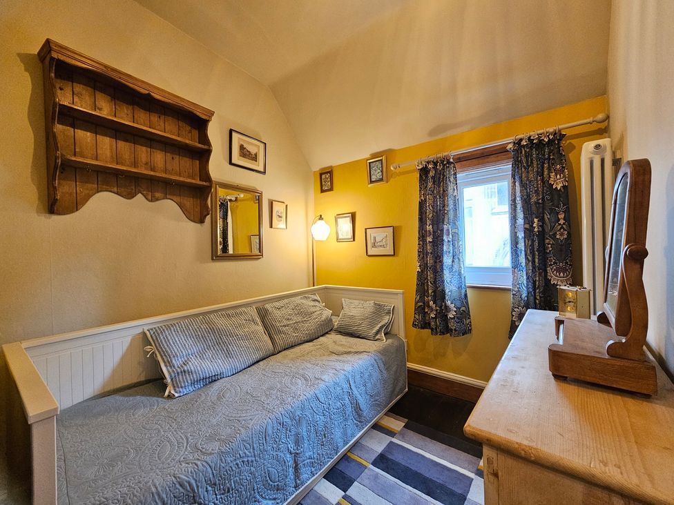 A bedroom with a day bed and shelves at Katie's Cottage in Church Stretton