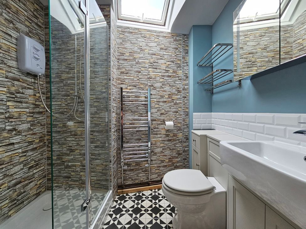 A bathroom with a shower, toilet, and sink at Katie's Cottage in Church Stretton