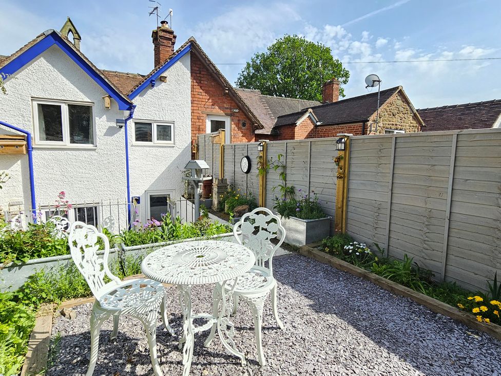 A garden with a table and chairs at Katie's Cottage in Church Stretton