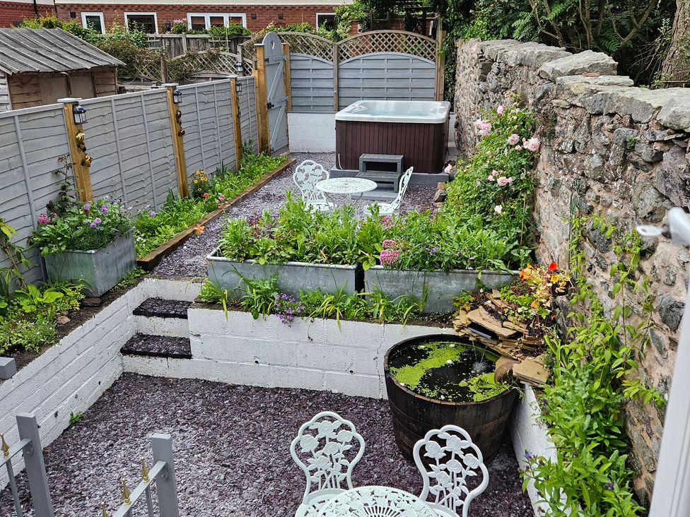 A garden with a hot tub and seating area at Katie's Cottage in Church Stretton