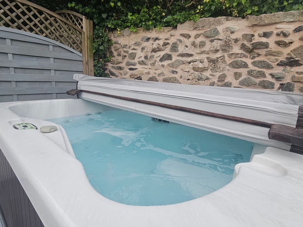 A hot tub with a cover and control panel in an outdoor area at Katie's Cottage in Church Stretton