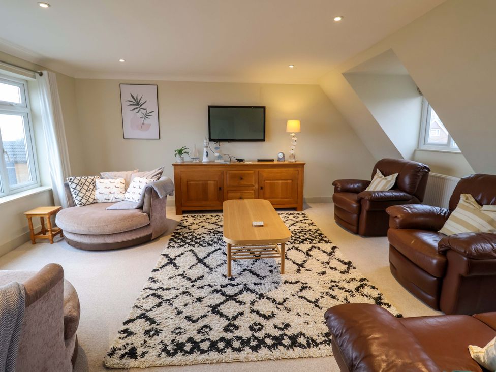 A living room with a sofa and chairs at Cliff Cottage