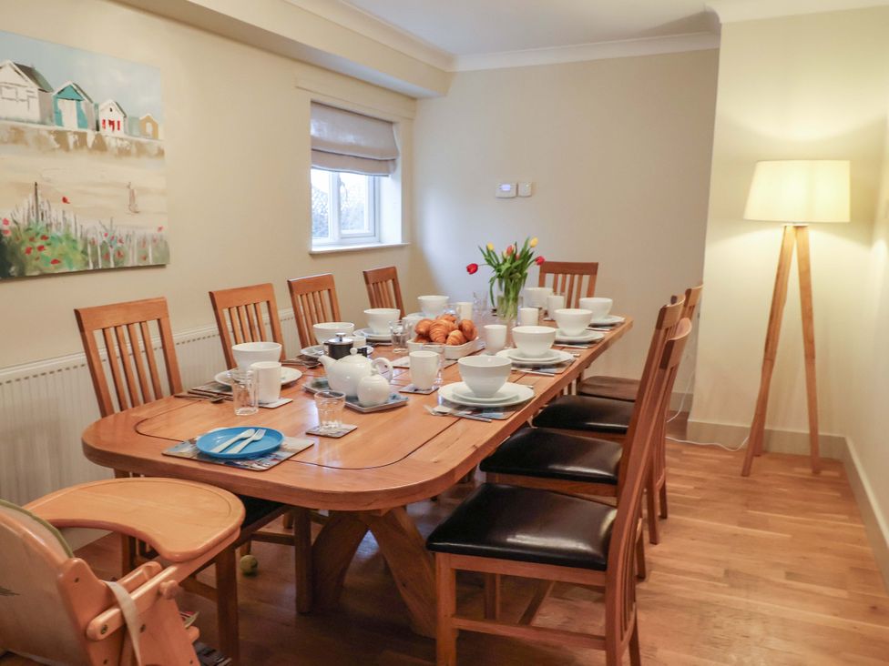 A dining room with a table set for a meal at Cliff Cottage