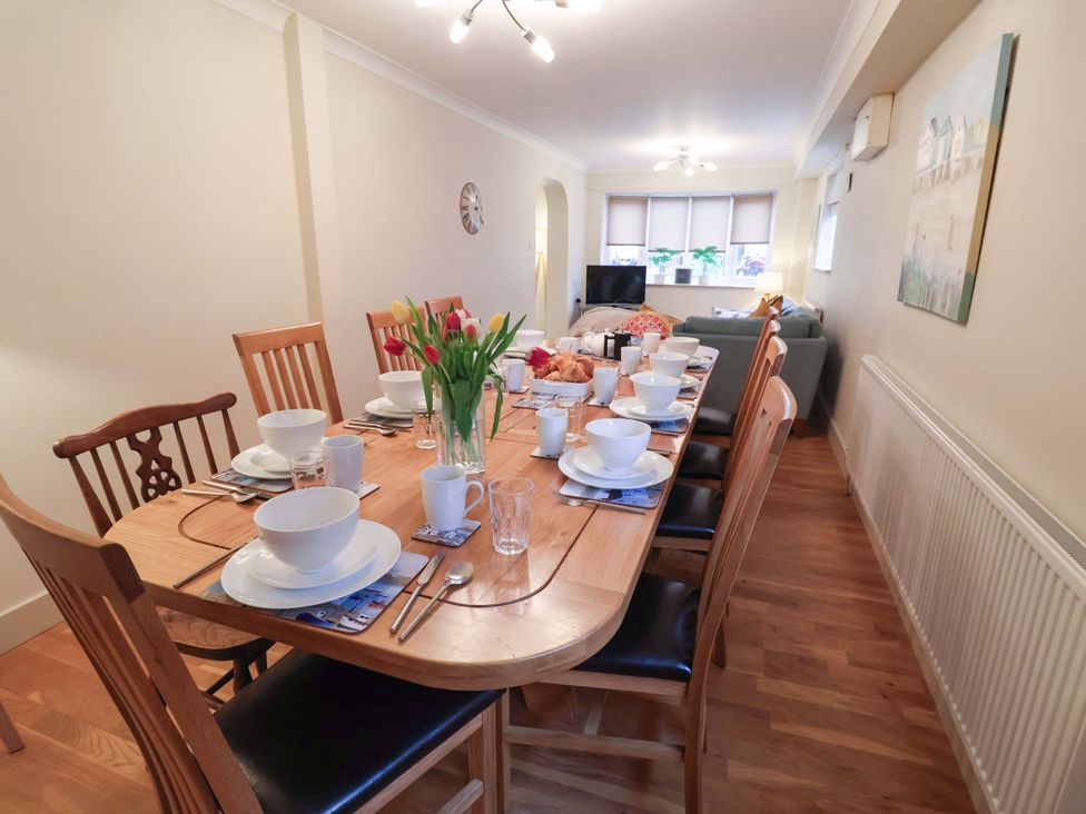 A dining room with a table set for a meal at Cliff Cottage