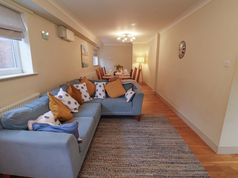 A living room with a sofa and dining area at Cliff Cottage