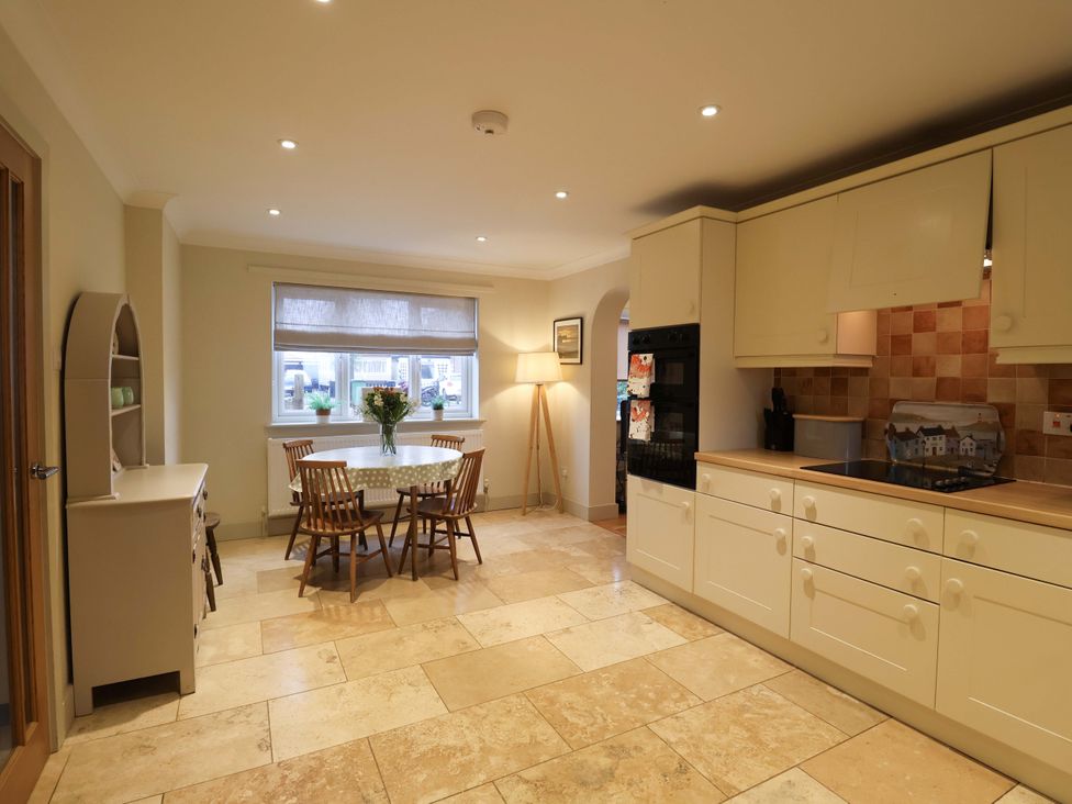 A kitchen with a table and chairs at Cliff Cottage