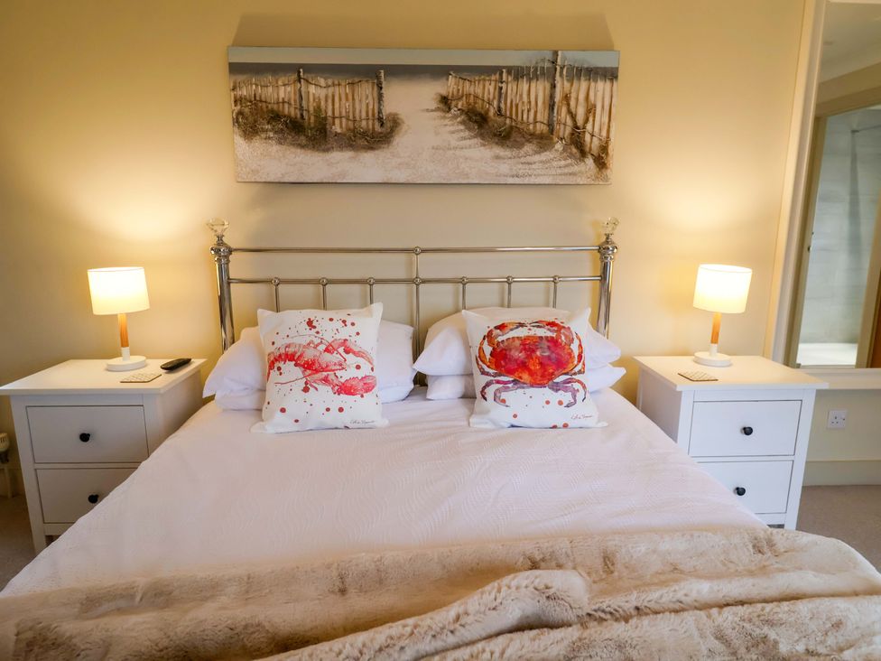 A bedroom with a bed and two bedside lamps at Cliff Cottage 