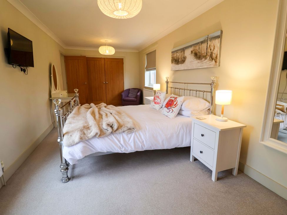 A bedroom with a bed and nightstand at Cliff Cottage 