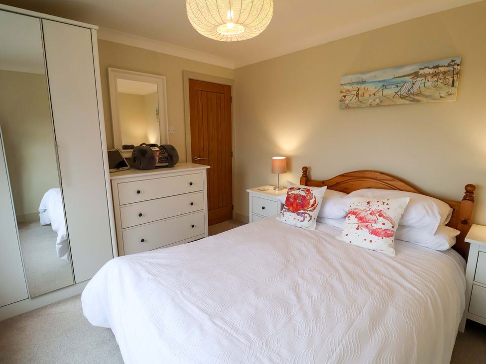 A bedroom with a bed and dresser at Cliff Cottage