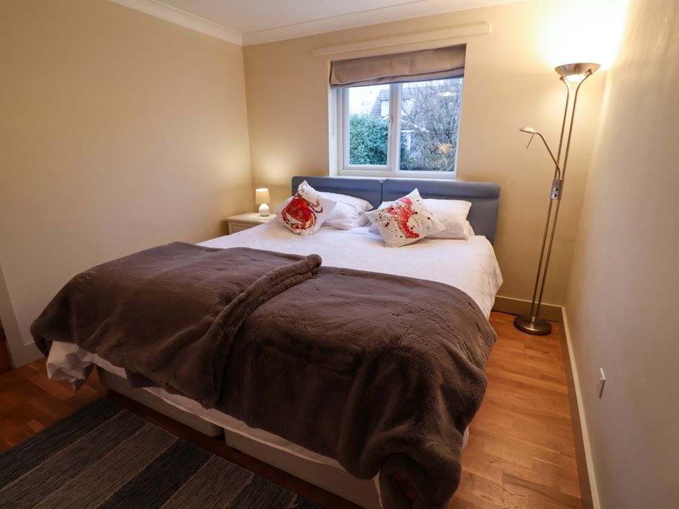 A bedroom with a bed and lamp at Cliff Cottage 