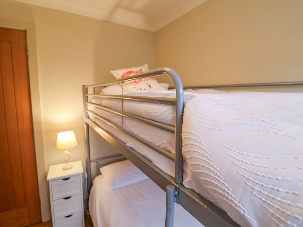 A bunk bed and lamp in a bedroom at Cliff Cottage