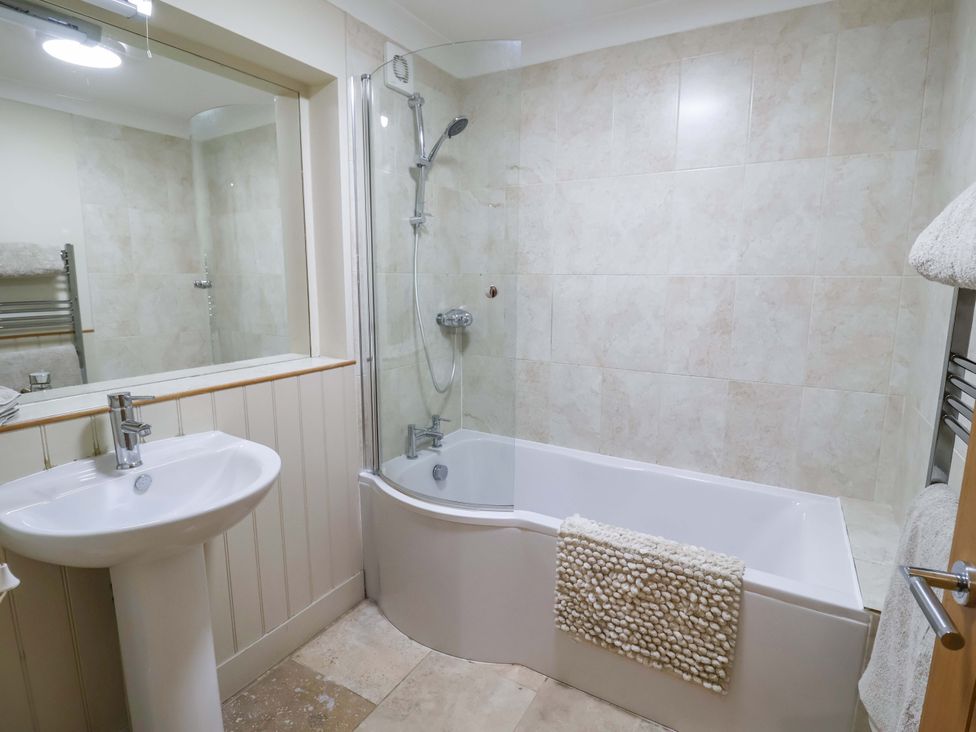 A bathroom with a bathtub and sink at Cliff Cottage