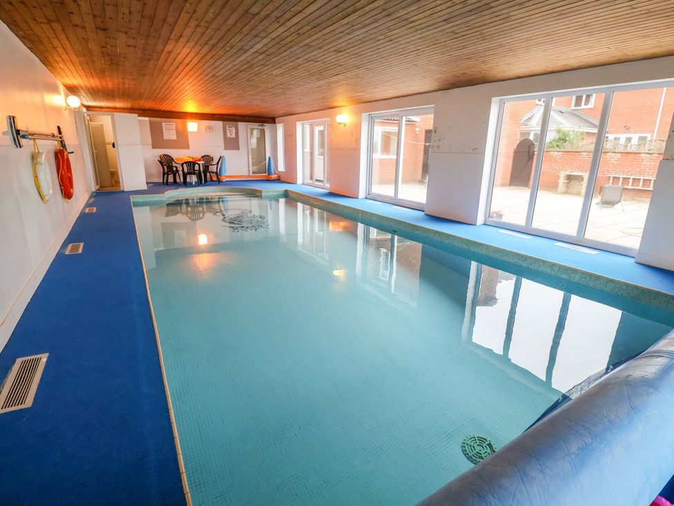 An indoor pool area with a swimming pool and seating at Cliff Cottage