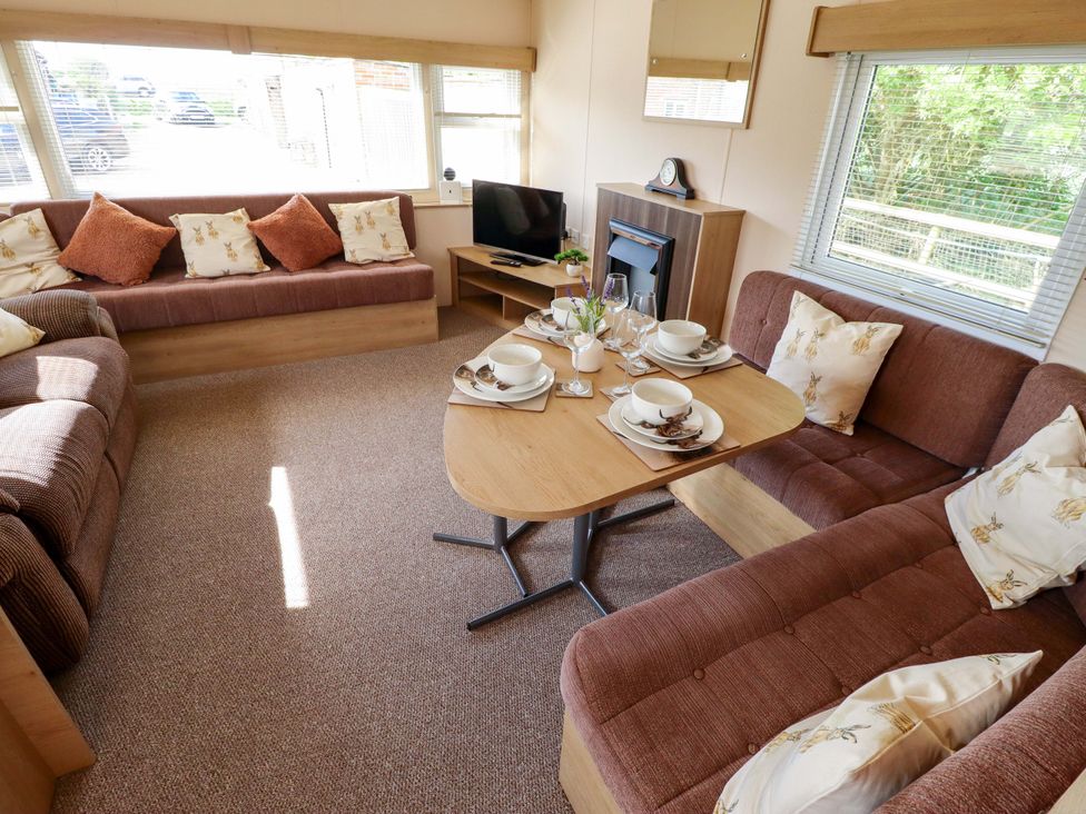 A living room with a sofa and dining table at Ewe View 