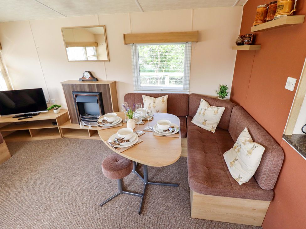 A living room with a sofa and dining table at Ewe View