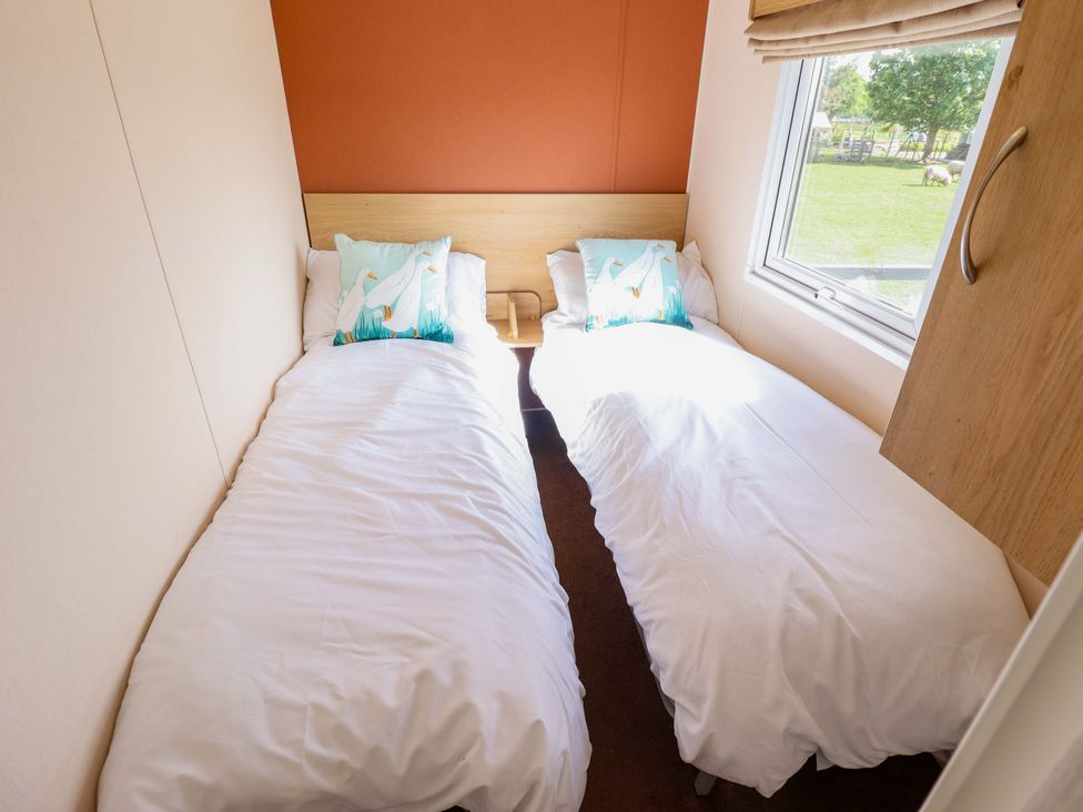 A bedroom with two beds and a window at Ewe View