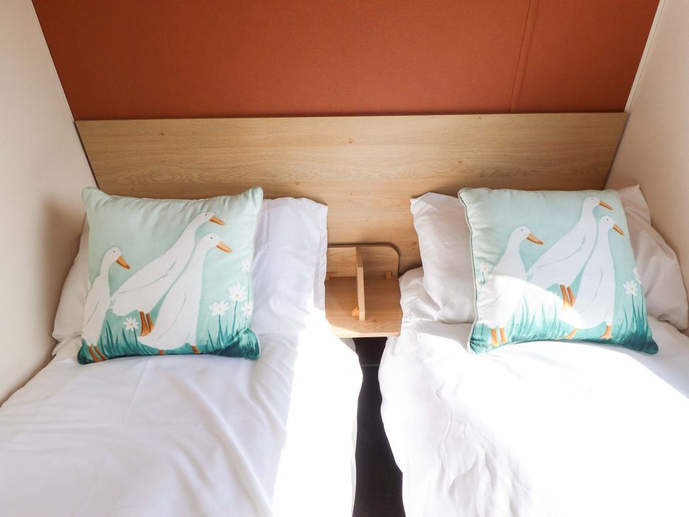 A bedroom with two beds and decorative pillows at Ewe View