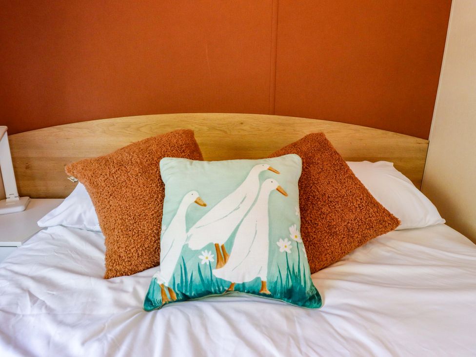 A bed with pillows and a decorative pillow at Ewe View