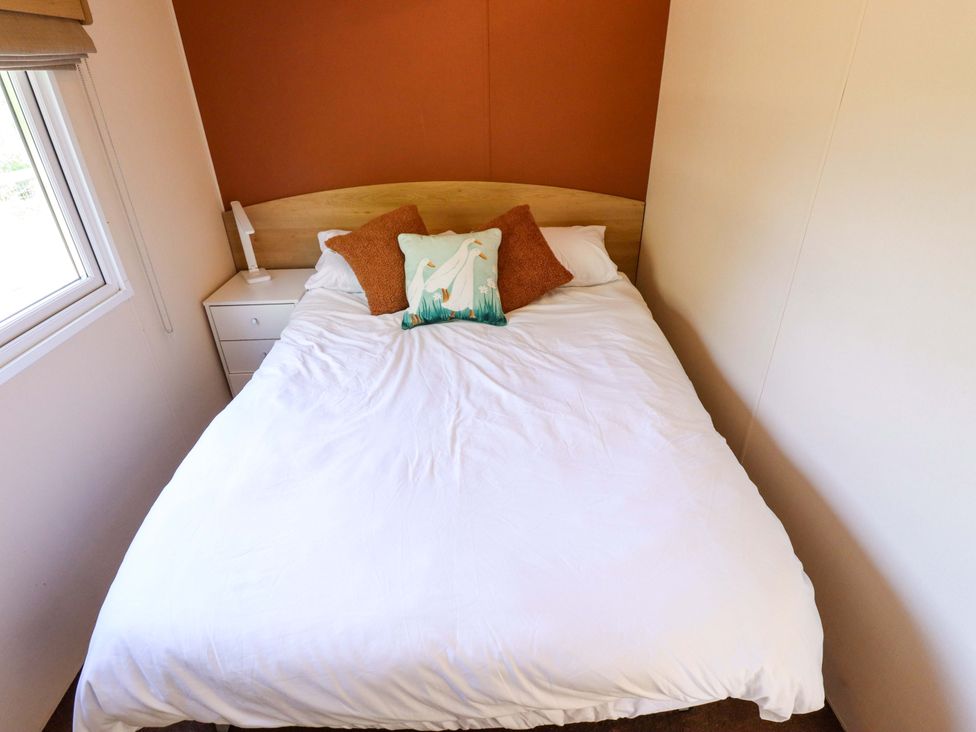 A bedroom with a bed and a nightstand at Ewe View